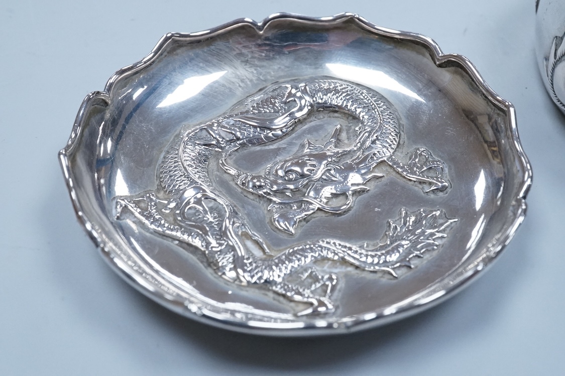An early 20th century Chinese Export white metal small trinket dish with dragon decoration, by Sing Fat, diameter 66mm, together with a larger Chinese Export white metal trinket dish, maker Tien Shing?.